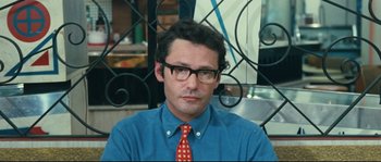 Movie still from “2 or 3 Things I Know About Her” (1967), directed by Jean-Luc Godard – A man wearing a blue shirt and a red neck tie; Close Up shot, Over the shoulder angle