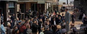Movie still from “20,000 Leagues Under the Sea” (1954), directed by Richard Fleischer – A group of men standing on the side of a street; Wide shot, High angle
