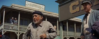 Movie still from “20,000 Leagues Under the Sea” (1954), directed by Richard Fleischer – An older man walking down the street in front of a building; Medium shot, Low angle