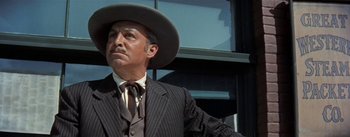 Movie still from “20,000 Leagues Under the Sea” (1954), directed by Richard Fleischer – A man wearing a suit and a cowboy hat in front of a window; Close Up shot, Low angle