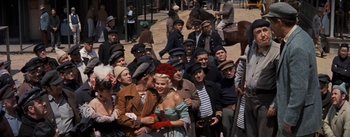 Movie still from “20,000 Leagues Under the Sea” (1954), directed by Richard Fleischer – A group of people standing next to each other on a street; Wide shot, High angle