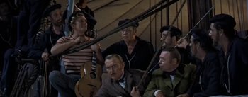 Movie still from “20,000 Leagues Under the Sea” (1954), directed by Richard Fleischer – A group of men sitting next to each other on a boat; Wide shot, High angle