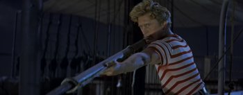 Movie still from “20,000 Leagues Under the Sea” (1954), directed by Richard Fleischer – A man holding a rifle in a room; Medium shot, Low angle