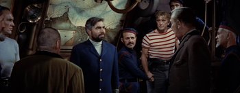 Movie still from “20,000 Leagues Under the Sea” (1954), directed by Richard Fleischer – A group of men standing next to each other in a room; Medium shot, High angle