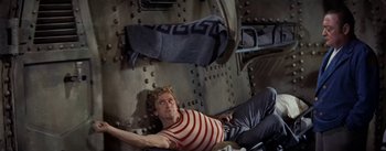 Movie still from “20,000 Leagues Under the Sea” (1954), directed by Richard Fleischer – A man laying on the ground in a room; Medium shot, Overhead angle