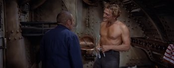 Movie still from “20,000 Leagues Under the Sea” (1954), directed by Richard Fleischer – Two men talking in front of an oven; Medium shot, Over the shoulder angle