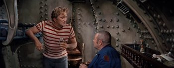 Movie still from “20,000 Leagues Under the Sea” (1954), directed by Richard Fleischer – Two men in striped shirts talking to each other; Medium shot, Over the shoulder angle