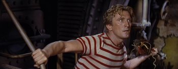 Movie still from “20,000 Leagues Under the Sea” (1954), directed by Richard Fleischer – A man in a striped shirt is holding something in his hand; Close Up shot, High angle
