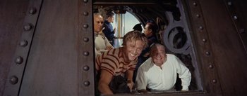 Movie still from “20,000 Leagues Under the Sea” (1954), directed by Richard Fleischer – A group of men standing next to each other on a boat; Medium shot, High angle