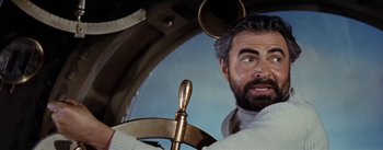 Movie still from “20,000 Leagues Under the Sea” (1954), directed by Richard Fleischer – A man with a beard and mustache is holding a steering wheel; Close Up shot, Low angle