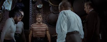 Movie still from “20,000 Leagues Under the Sea” (1954), directed by Richard Fleischer – A man standing in front of another man in front of a mirror; Medium shot, Over the shoulder angle