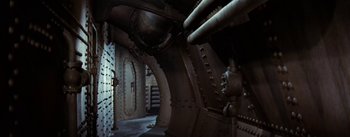 Movie still from “20,000 Leagues Under the Sea” (1954), directed by Richard Fleischer – A room filled with pipes and a door way; Extreme Wide shot, Overhead angle