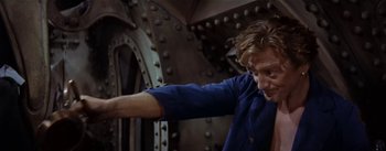 Movie still from “20,000 Leagues Under the Sea” (1954), directed by Richard Fleischer – A man in a blue shirt is pointing to something in his hand; Medium shot, Low angle