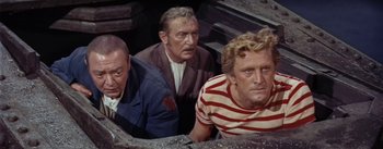 Movie still from “20,000 Leagues Under the Sea” (1954), directed by Richard Fleischer – A group of men standing next to each other in a room; Medium shot, High angle