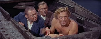 Movie still from “20,000 Leagues Under the Sea” (1954), directed by Richard Fleischer – A group of men standing next to each other; Medium shot, High angle