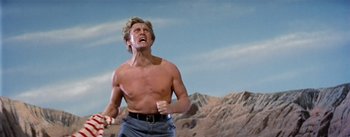 Movie still from “20,000 Leagues Under the Sea” (1954), directed by Richard Fleischer – A shirtless man in the middle of an open field; Medium shot, Low angle