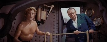 Movie still from “20,000 Leagues Under the Sea” (1954), directed by Richard Fleischer – A man in a suit and tie standing next to another man in a suit and tie; Medium shot, Over the shoulder angle