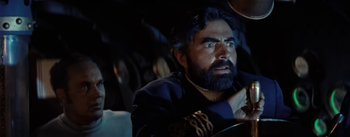 Movie still from “20,000 Leagues Under the Sea” (1954), directed by Richard Fleischer – A man sitting in a car looking at the camera; Close Up shot, Overhead angle