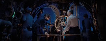 Movie still from “20,000 Leagues Under the Sea” (1954), directed by Richard Fleischer – A group of men standing next to each other in a room; Medium shot, High angle