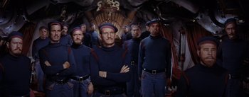 Movie still from “20,000 Leagues Under the Sea” (1954), directed by Richard Fleischer – A group of men standing next to each other in uniforms; Medium shot, Low angle