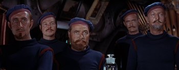 Movie still from “20,000 Leagues Under the Sea” (1954), directed by Richard Fleischer – A group of men standing next to each other on a boat; Medium shot, Low angle