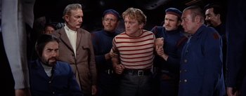 Movie still from “20,000 Leagues Under the Sea” (1954), directed by Richard Fleischer – A group of men standing next to each other in a room; Medium shot, High angle