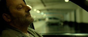 Movie still from “22 Bullets” (2010), directed by Richard Berry – A person sitting in a car; Close Up shot, Low angle