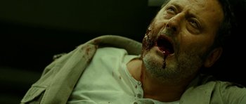 Movie still from “22 Bullets” (2010), directed by Richard Berry – A person laying on a bed with blood on his face; Close Up shot, Overhead angle