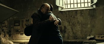 Movie still from “22 Bullets” (2010), directed by Richard Berry – A man and a woman hugging in a room; Medium shot, Over the shoulder angle