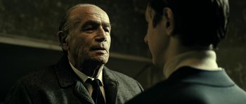 Movie still from “22 Bullets” (2010), directed by Richard Berry – An older man and a younger man are talking to each other; Close Up shot, Over the shoulder angle