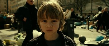 Movie still from “22 Bullets” (2010), directed by Richard Berry – A young boy is looking into the camera; Close Up shot, High angle
