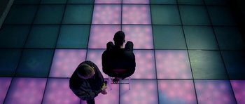 Movie still from “22 Bullets” (2010), directed by Richard Berry – Two men standing on a tiled dance floor; Wide shot, Overhead angle