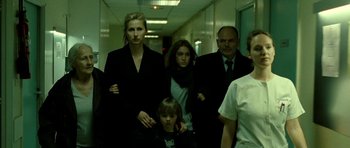 Movie still from “22 Bullets” (2010), directed by Richard Berry – A group of people walking down a hall way; Medium shot, Low angle
