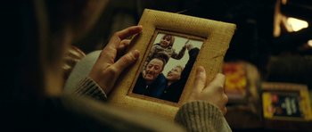 Movie still from “22 Bullets” (2010), directed by Richard Berry – A person holding a picture frame with a picture of a man and a child; Extreme Close Up shot, High angle