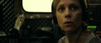 Movie still from “22 Bullets” (2010), directed by Richard Berry – A woman wearing headphones looking into the distance; Close Up shot, Low angle