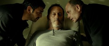 Movie still from “22 Bullets” (2010), directed by Richard Berry – A man is in a hospital bed with two other men; Close Up shot, Low angle