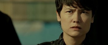 Movie still from “22 Bullets” (2010), directed by Richard Berry – A person wearing a leather jacket; Close Up shot, Over the shoulder angle