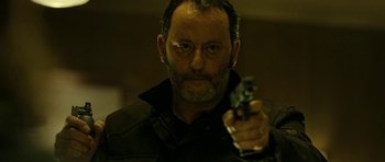 Movie still from “22 Bullets” (2010), directed by Richard Berry – A person holding a gun; Close Up shot, Low angle