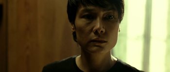 Movie still from “22 Bullets” (2010), directed by Richard Berry – A person with short black hair; Close Up shot, Over the shoulder angle