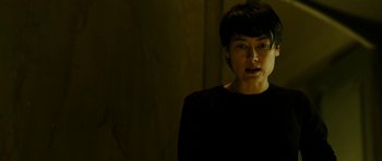 Movie still from “22 Bullets” (2010), directed by Richard Berry – A person standing in a dark room with a dark background; Close Up shot, Low angle