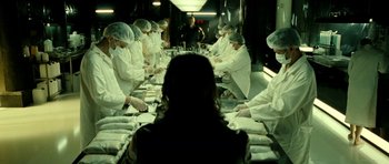 Movie still from “22 Bullets” (2010), directed by Richard Berry – A group of people sitting at a table with food; Medium shot, Over the shoulder angle