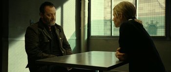 Movie still from “22 Bullets” (2010), directed by Richard Berry – A man and a woman sitting at a table talking to each other; Medium shot, Over the shoulder angle
