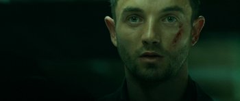 Movie still from “22 Bullets” (2010), directed by Richard Berry – A person's face in a dark room; Close Up shot, Overhead angle