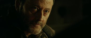 Movie still from “22 Bullets” (2010), directed by Richard Berry – A person with a beard looking at the camera; Close Up shot, Over the shoulder angle