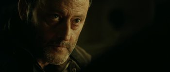 Movie still from “22 Bullets” (2010), directed by Richard Berry – A person's face in a dark room; Close Up shot, Over the shoulder angle