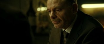 Movie still from “22 Bullets” (2010), directed by Richard Berry – A person wearing a suit and tie; Close Up shot, Over the shoulder angle