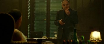 Movie still from “22 Bullets” (2010), directed by Richard Berry – A man standing in front of a dining room table; Medium shot, Over the shoulder angle