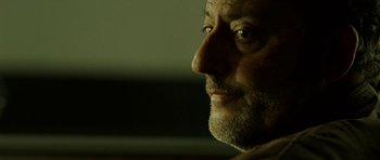 Movie still from “22 Bullets” (2010), directed by Richard Berry – A man's face in a dark room; Close Up shot, Low angle