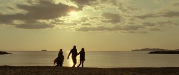 Movie still from “22 Bullets” (2010), directed by Richard Berry – A group of people standing on top of a sandy beach; Extreme Wide shot, Low angle