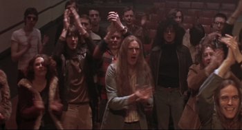 Movie still from “24 Hour Party People” (2002), directed by Tom Bruggen – A group of people standing in front of a wall; Medium shot, High angle